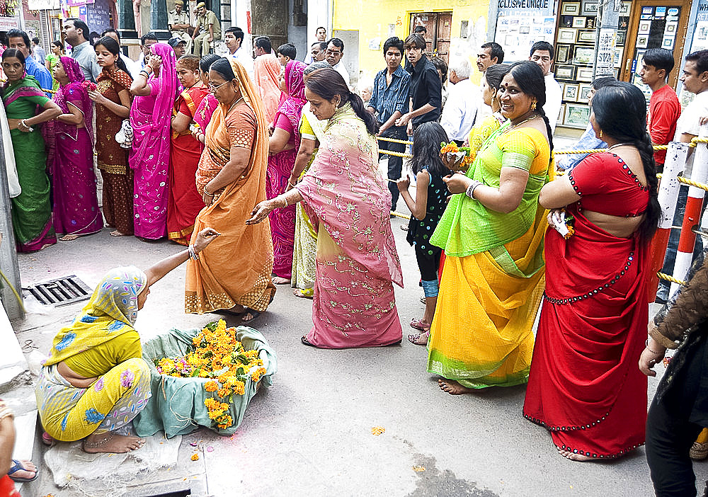 Women queueing for Diwali temple puja, buying garlands as offerings for the deity, Udaipur, Rajasthan, India, Asia