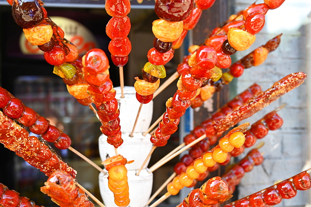 Tanghulu, skewered sugar-glazed berries sold in the outdoor market places or from street carts, Beijing, China, Asia