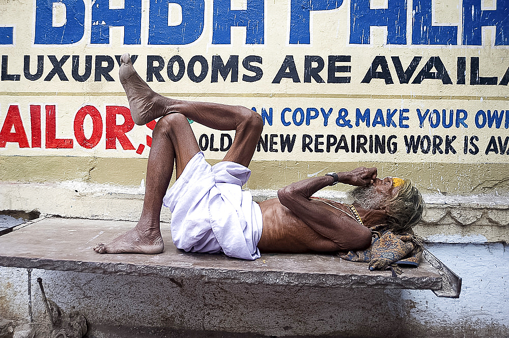 Holy man (Saddhu) resting on a marble slab, Udaipur, Rajasthan, India, Asia