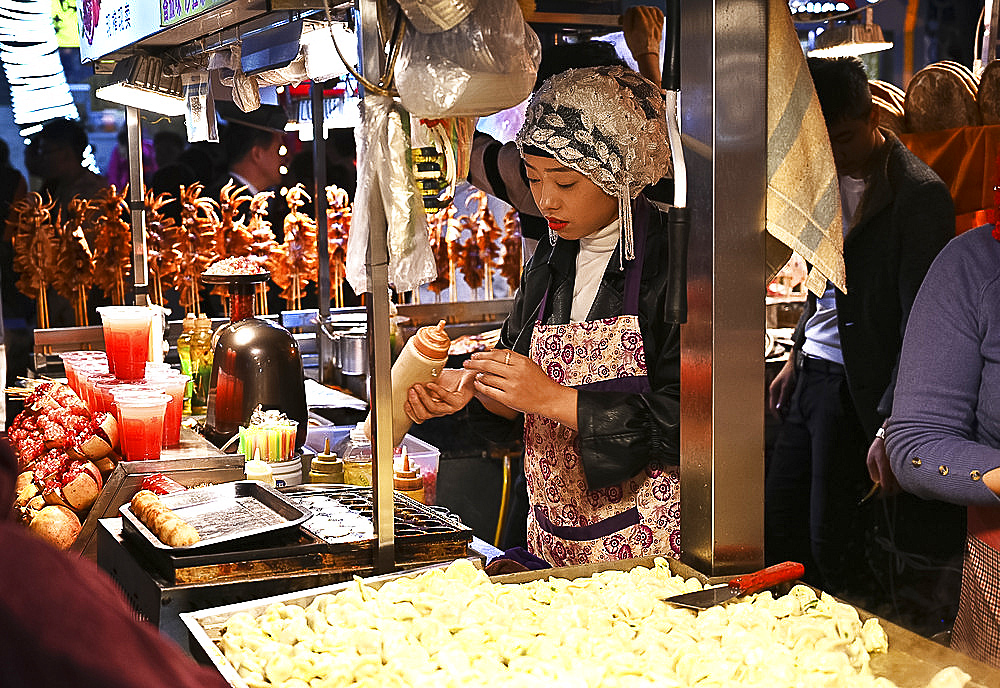 Muslim woman selling food at stall in Huajue night market, Xian, Shaanxi, China, Asia