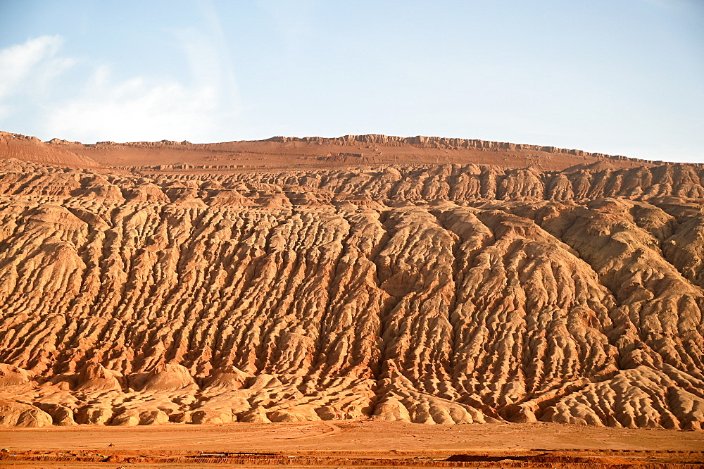 Buildings dwarfed by vast Gobi desert landscape along the Silk Road near Turfan, Xinjiang, China, Asia