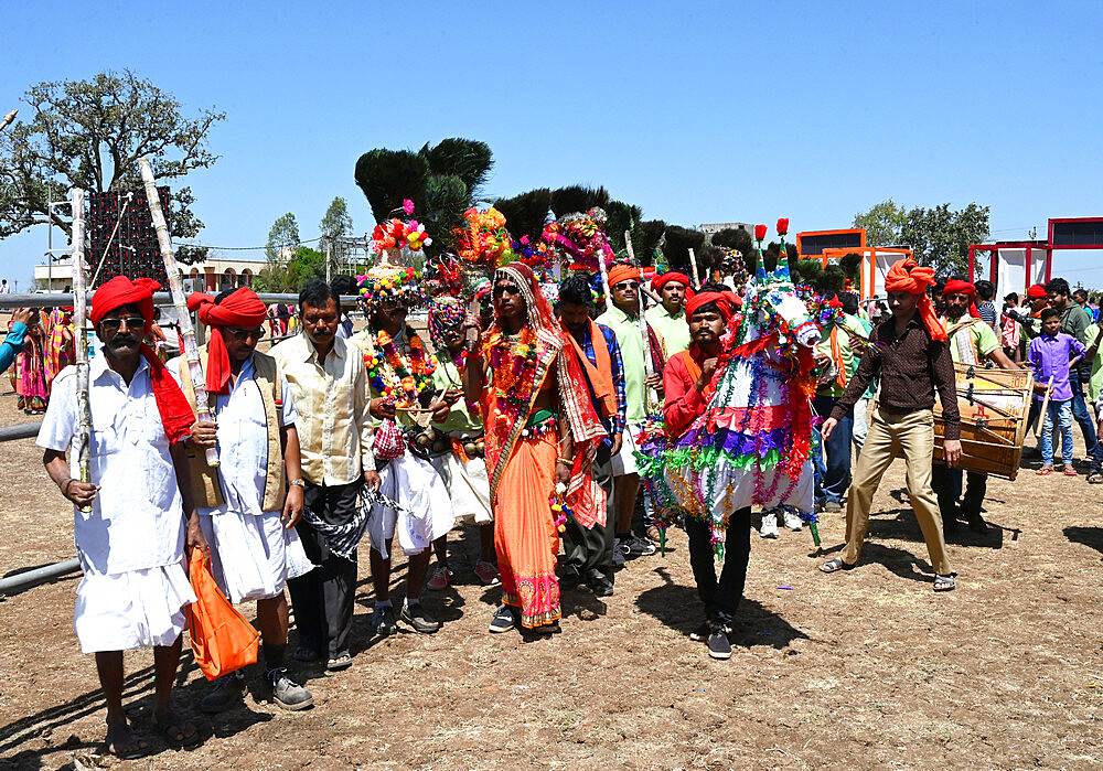 Adivasi tribal men, faces and bodies decorated, wearing ornate headgear, dancing to celebrate Holi festival, Kavant, Gujarat, India, Asia