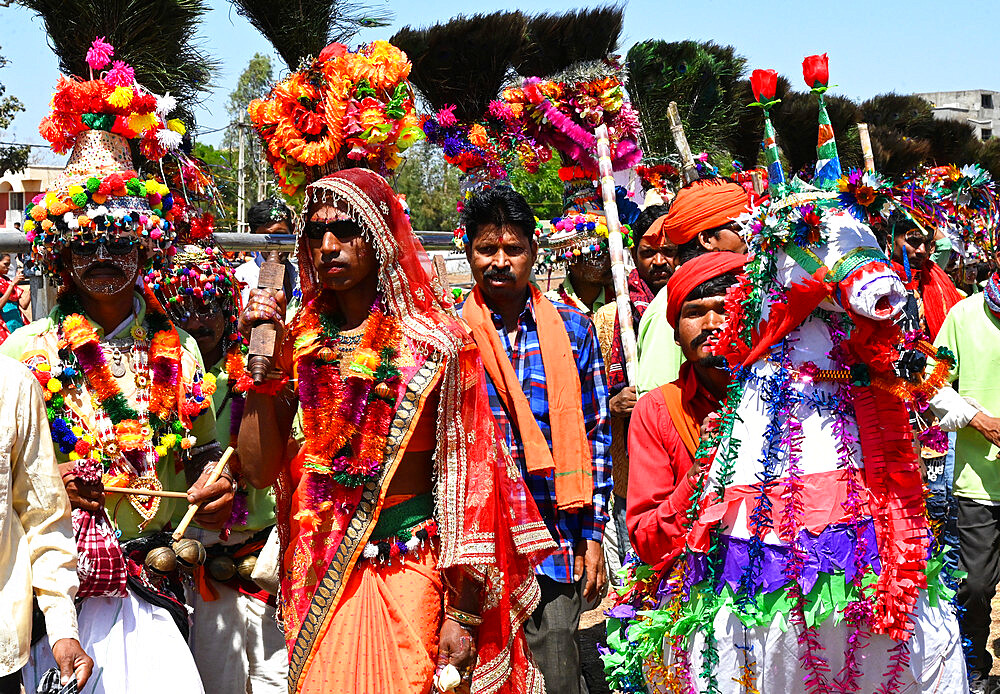 Adivasi tribal men, faces and bodies decorated, wearing ornate headgear, dancing to celebrate Holi festival, Kavant, Gujarat, India, Asia