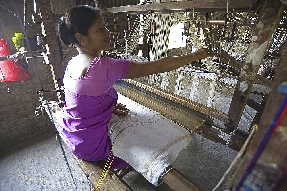 Woman at village silk loom weaving Assam Muga natural undyed silk in Sualkuchi, Assam, India, Asia