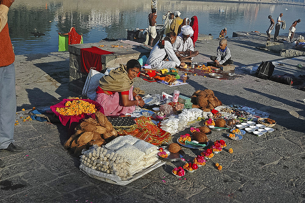 Woman selling holy puja items at sunrise by the sacred Shipra river, Ujjain, Madhya Pradesh, India, Asia