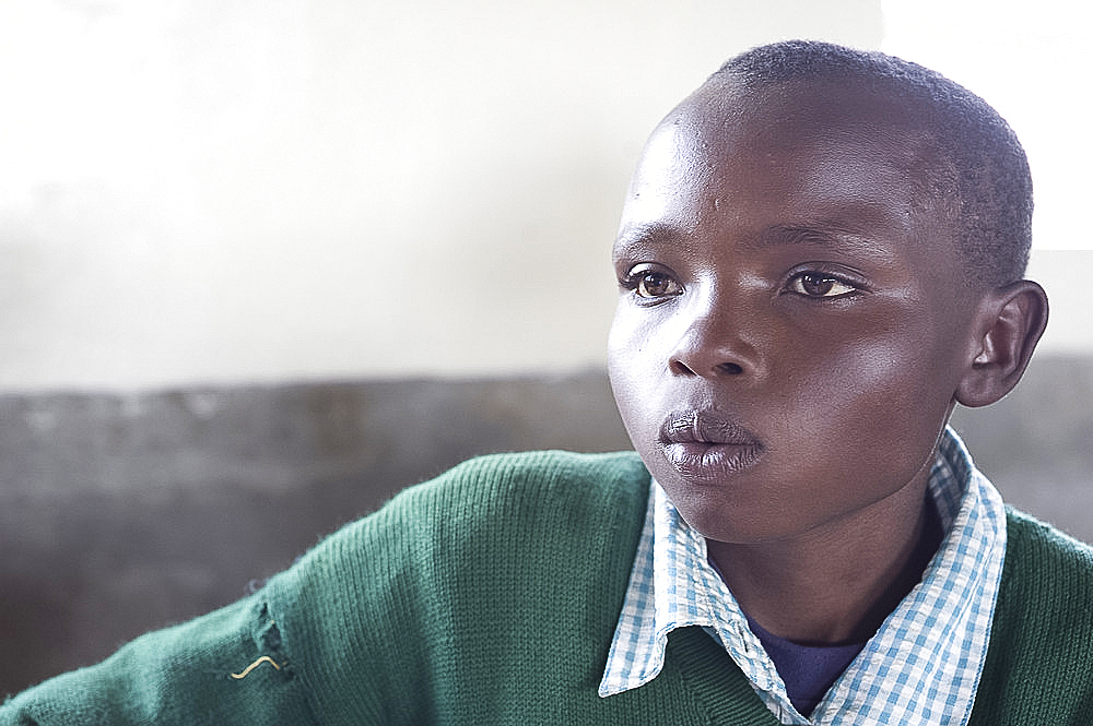 Schoolboy in school uniform, concentrating, Ngeteti Primary School, Rift Valley, Kenya, East Africa, Africa