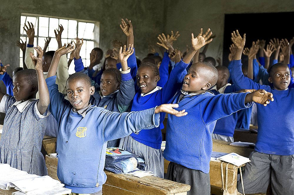 Schoolchildren in classroom, offering traditional Kikuyu welcome by waving hands as if offering flowers, Karunga Primary School, Rift Valley, Kenya, East Africa, Africa