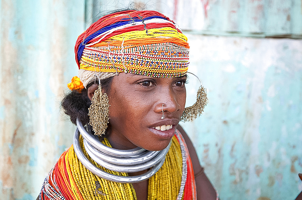 Bonda tribeswoman wearing traditional bead costume with beaded cap, large earrings, nose ring and metal necklaces at weekly market, Rayagader, Orissa, India, Asia