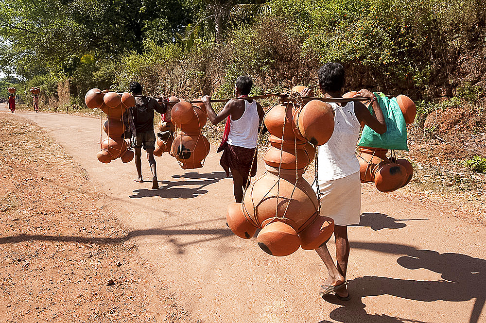 Bonda tribesmen walking to market carrying pots intended for village alcohol production, rural Orissa, India, Asia