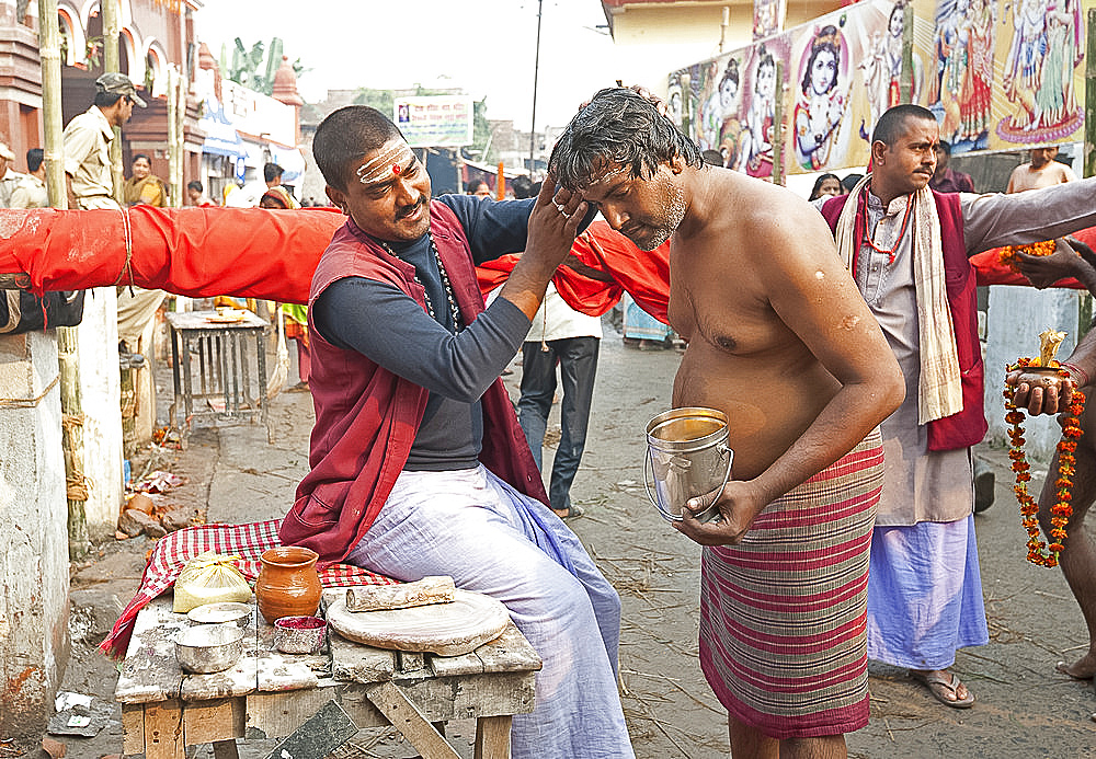 Pundit making Brahman sandalwood paste tilak on Hindu worshipper's forehead outside Hariharnath temple, Sonepur, Bihar, India, Asia