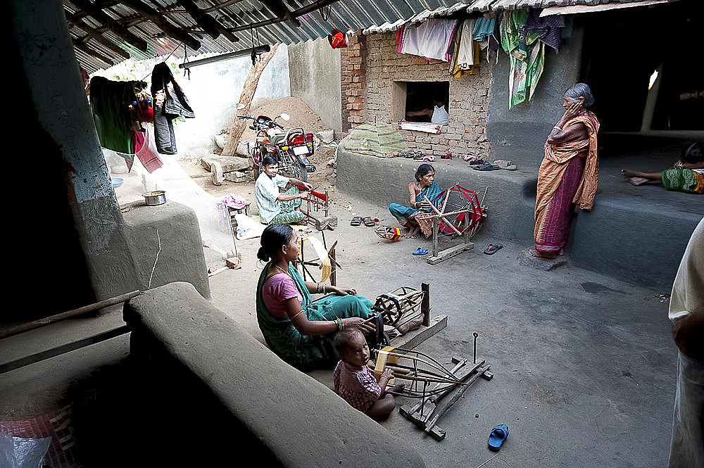 Women in communal back yard of weaving village, spinning silk thread ready for the looms, Vaidyanathpur weaving village, Orissa, India, Asia