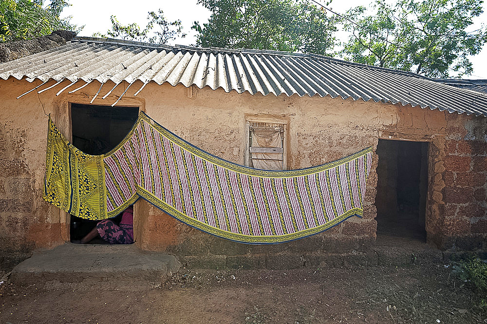 Cotton sari being hung out to dry across village house wall, rural Orissa, India, Asia