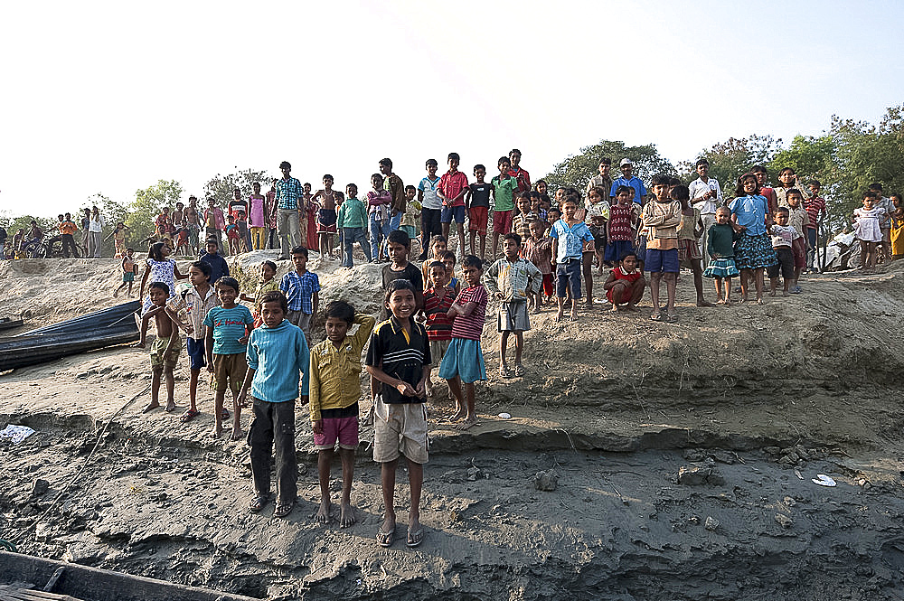 Villagers waiting on the riverbank of the River Hugli to welcome visitors arriving by boat, rural West Bengal, India, Asia