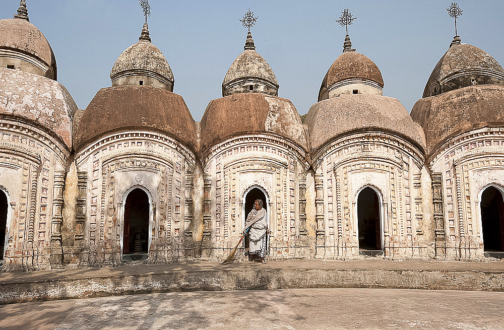 Woman with broom emerging from one of 108 Shiva temples built by Maharaja Teja Chandra Bahadur in 1809, Kalna, West Bengal, India, Asia