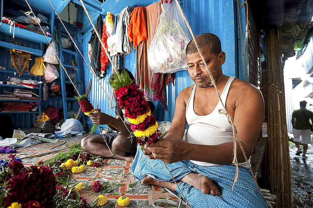 Mala makers (garland makers) at work in Kolkata's morning flower market, Howrah, Kolkata, West Bengal, India, Asia