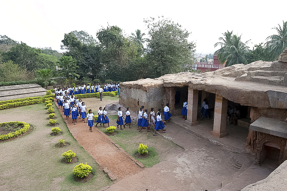 Local schoolchildren in blue and white school uniform visiting Ranigumpha, cave number 1, Udayagiri caves, Bhubaneshwar, Orissa, India, Asia