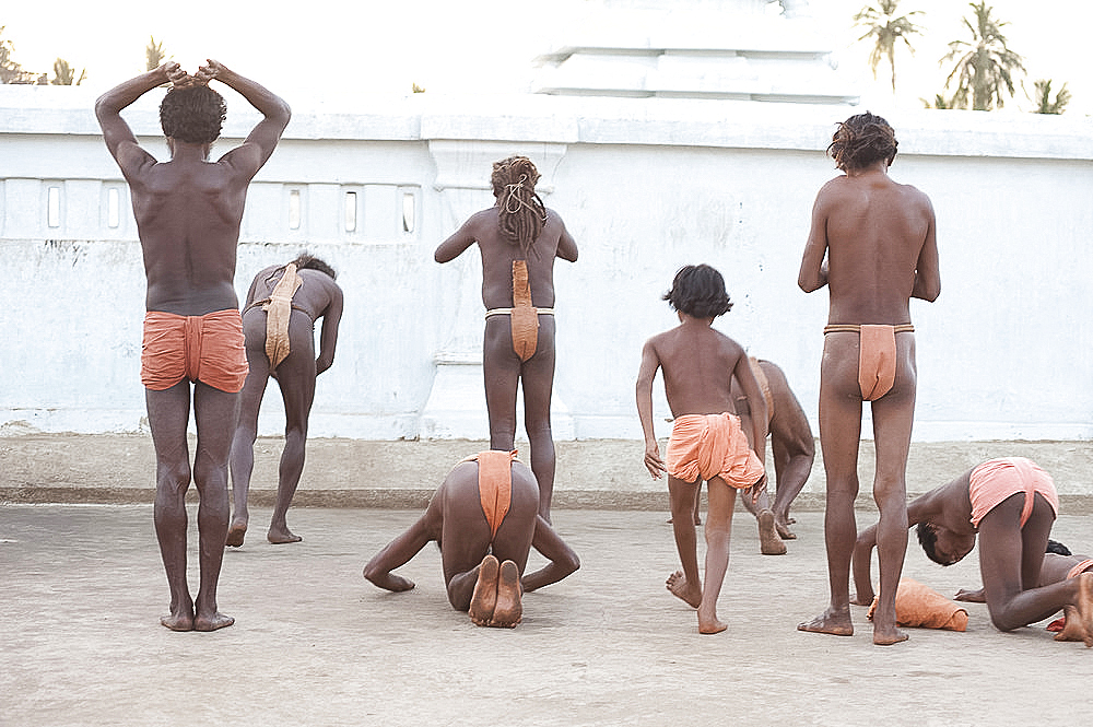 Joranda monks performing obeisance at temple containing a dhuni, an eternal butter lamp, at dusk, Joranda, Dhenkanal, Orissa, India, Asia