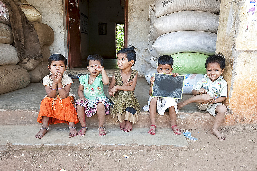 Untouchable village children sitting outside their house in brassmaking Dokhra village, rural Orissa, India, Asia