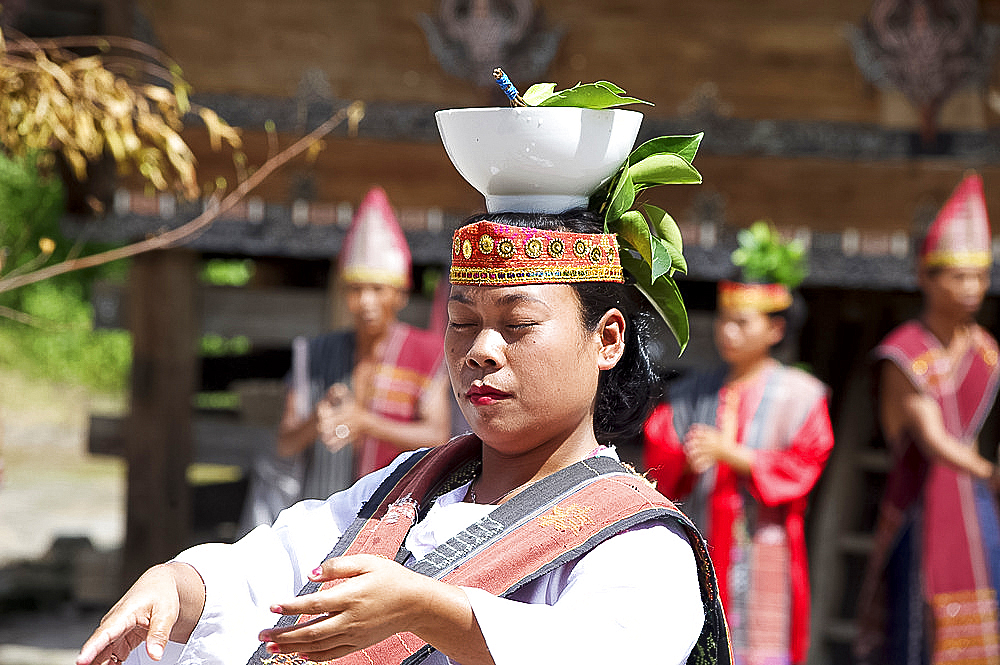 Young Batak woman performing courtship dance, bowl of water and leaves symbolising commitment, Huta Bolon, Simanindo, Sumatra, Indonesia, Southeast Asia, Asia