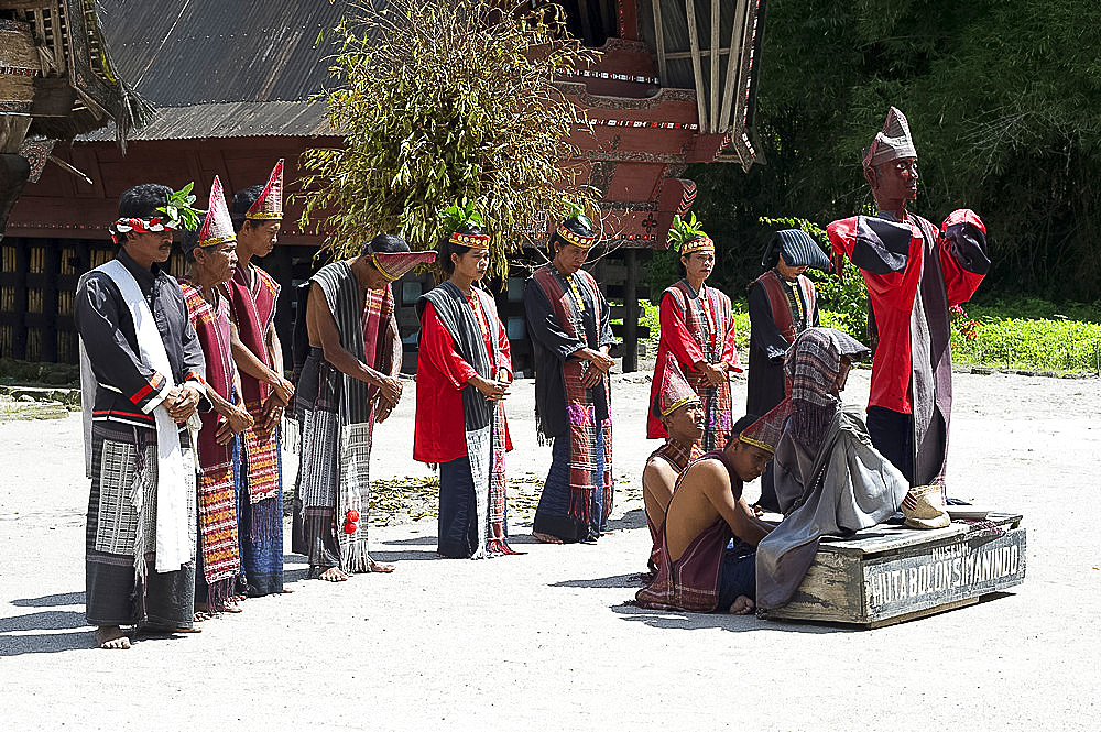 Batak dancers round a large wooden puppet symbolising the king's dead son, inviting villagers to dance, Simanindo, Sumatra, Indonesia, Southeast Asia, Asia