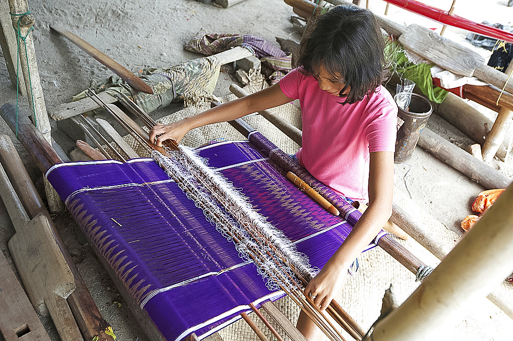 Young Batak tribeswoman weaving sarong with traditional Batak Toba design, Buhit, Samosir Island, Lake Toba, Sumatra, Indonesia, Southeast Asia, Asia