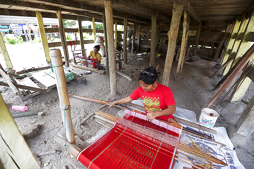 Batak woman weaving Batak Toba design sarong beneath her traditional Batak house, Buhit, Samosir Island, Lake Toba, Sumatra, Indonesia, Southeast Asia, Asia