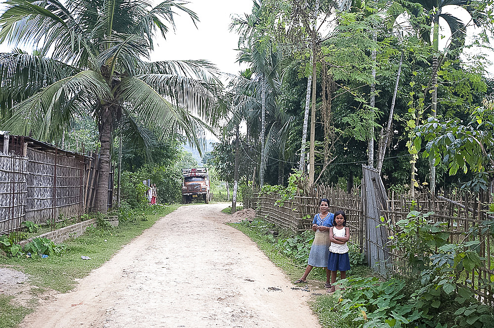 Mother and daughter in typical rural village street, Bijaynagar, Assam, India, Asia