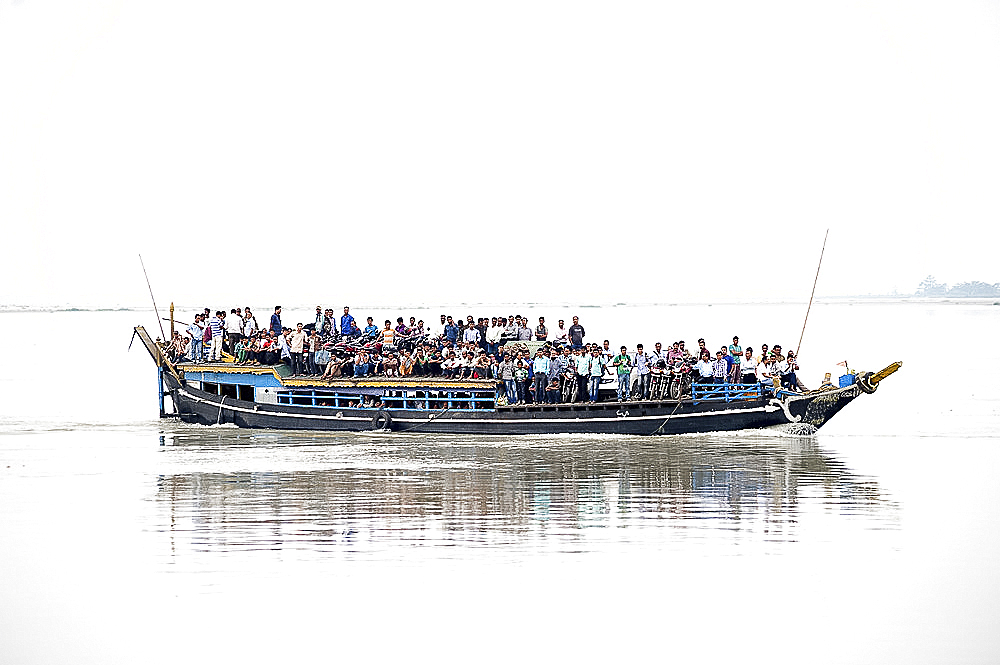 Crowded morning ferryboat carrying office workers and their motorbikes, across the Brahmaputra River, Guwahati, Assam, India, Asia