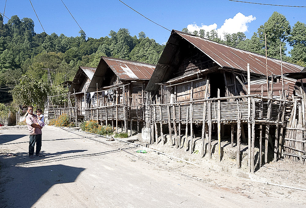 Apatani father and daughter in Apatani village street of traditional stilted bamboo built houses, Hari, Ziro, Arunachal Pradesh, India, Asia