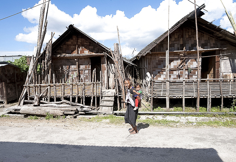 Apatani grandmother and child in Apatani tribal village street of traditional bamboo built houses, Ziro, Arunachal Pradesh, India, Asia