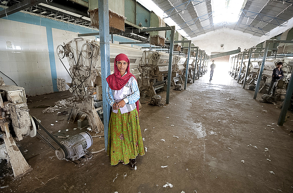 Female factory worker managing machinery in cotton processing factory, Rajkot district, Gujarat, India, Asia