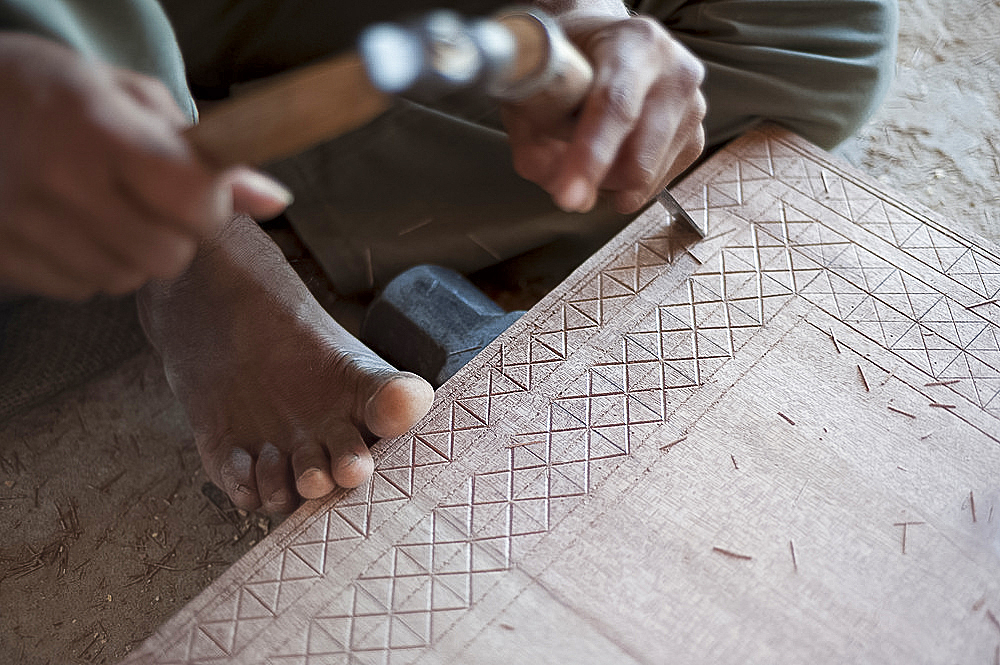 Carpenter chiselling traditional pattern in a piece of wood ready for varnished domestic furniture, Soyla, Kachchh (Kutch), Gujarat, India, Asia