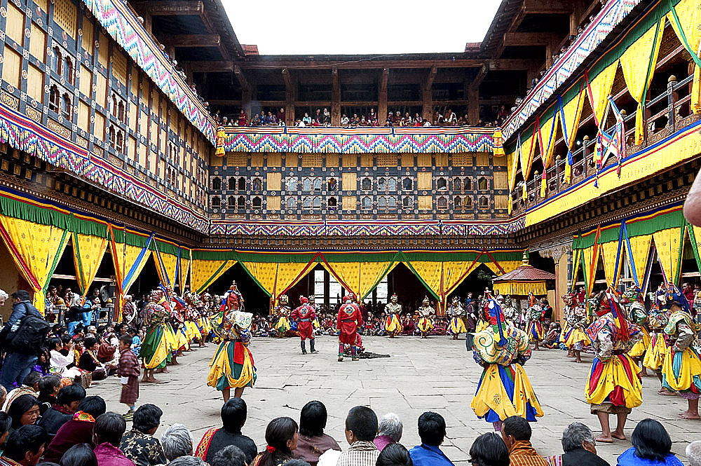 Monks performing religious ceremonial dances in the inner monastery courtyard at the Paro Tsechu (annual monastery festival), Paro, Bhutan, Asia