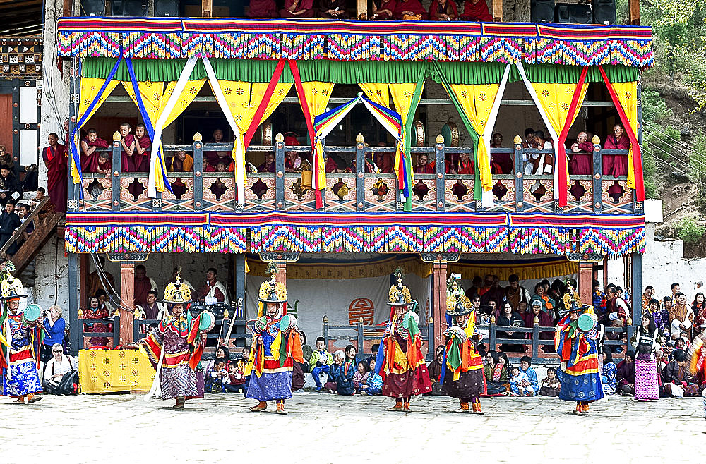 Monks watching dance performance at Paro Dzong (monastery) at the Paro Tsechu (annual monastery festival), Paro, Bhutan, Asia