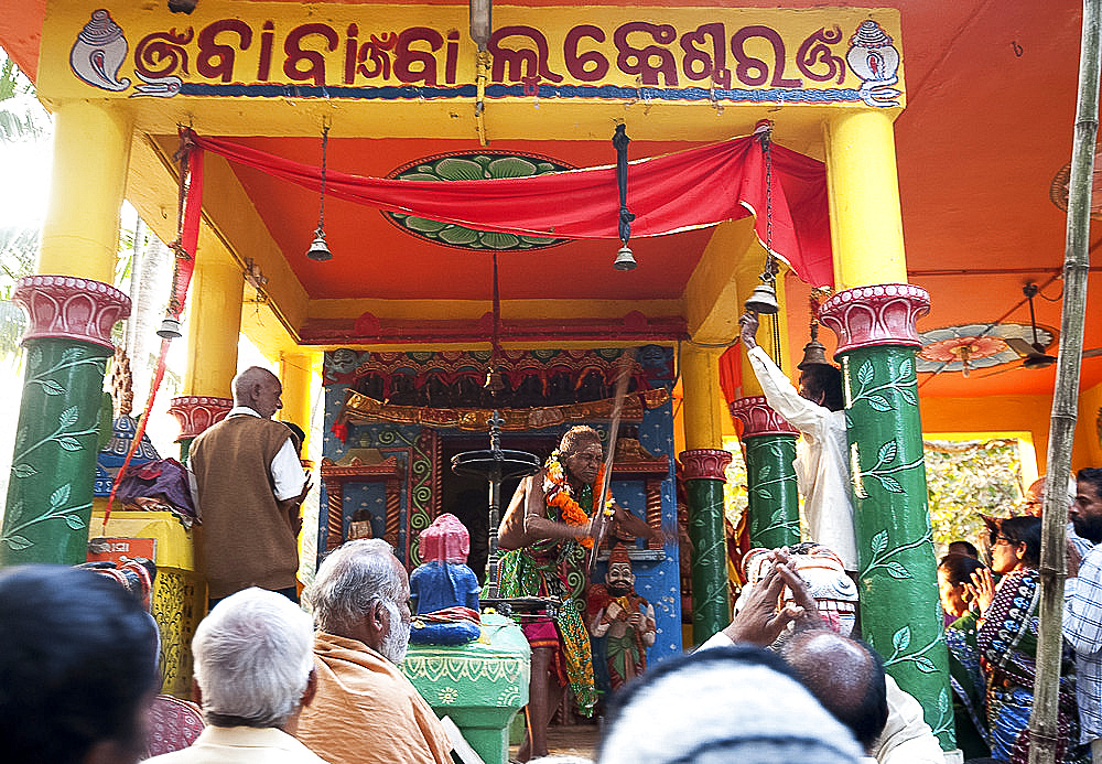 Shaman in highly altered state of consciousness performing problem-solving ritual for villagers gathered in Hindu temple, Odisha, India, Asia