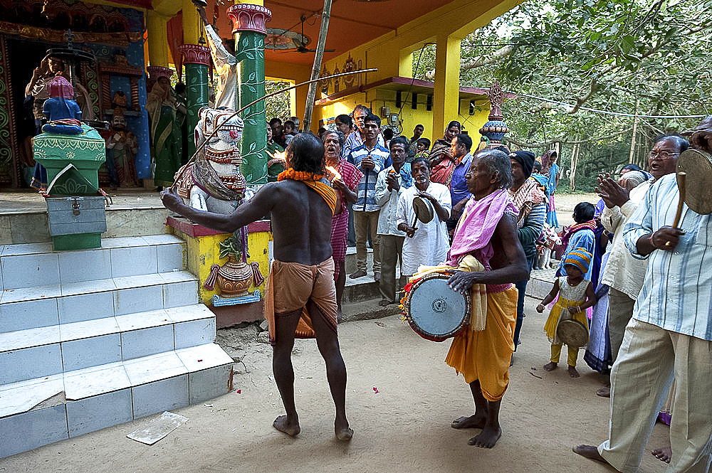 Shaman in altered state of consciousness with Shamanic drummer and cymbal, performing problem-solving ritual in Hindu temple, Kurkuri, Odisha, India, Asia