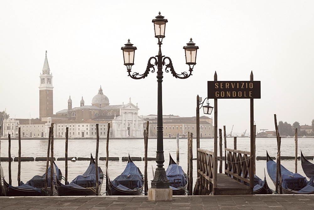 Gondolas moored on the Lagoon, San Giorgio Maggiore beyond, Riva degli Schiavoni, Venice, UNESCO World Heritage Site, Veneto, Italy, Europe