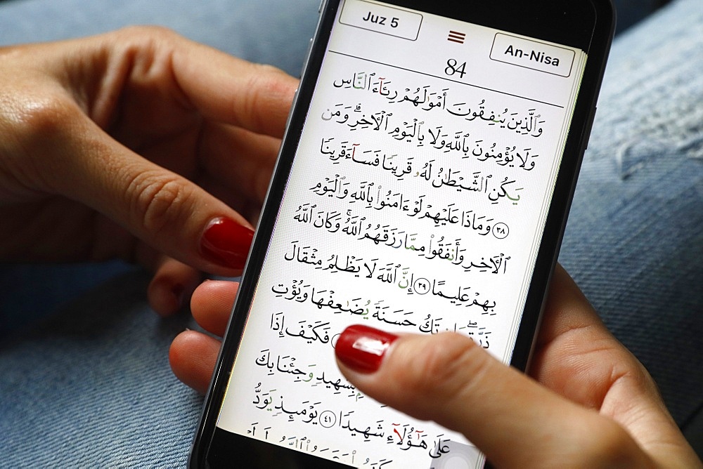 Young Muslim woman reading a digital Quran on a smartphone, Vietnam, Southeast Asia, Asia