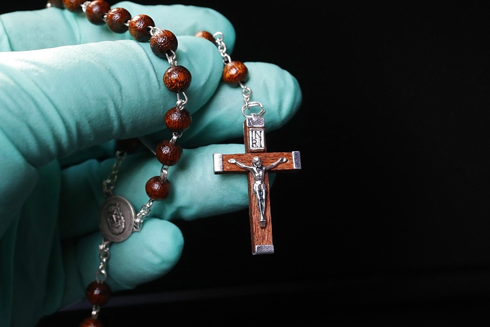 Coronavirus (COVID-19) epidemic, Christian praying rosary beads with protecting glove, France, Europe