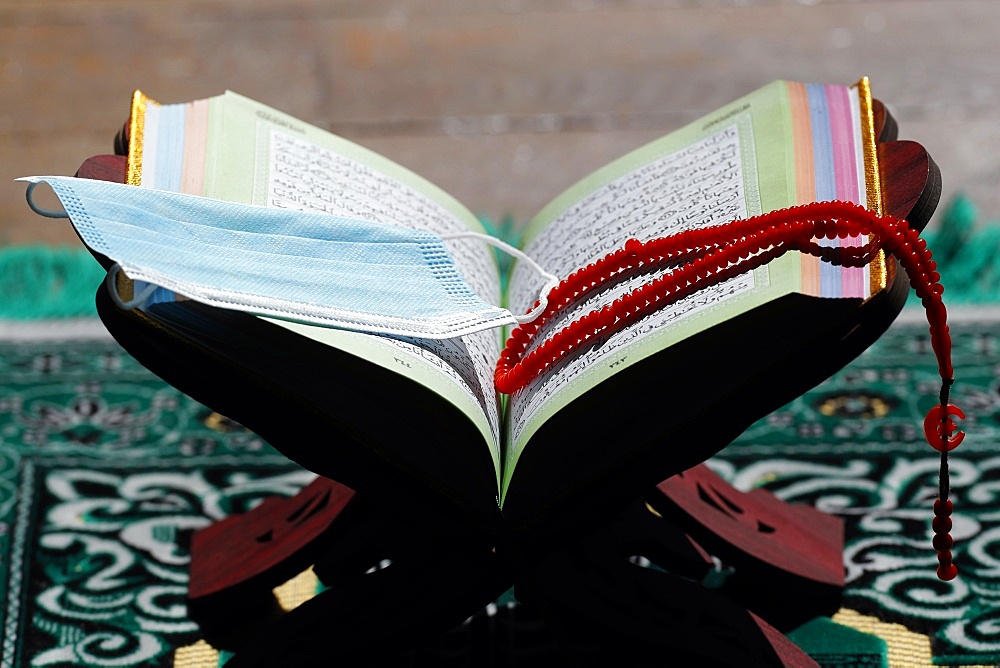 Coronavirus (COVID-19) epidemic, an open Holy Quran, Muslim prayer beads and a mask, France, Europe