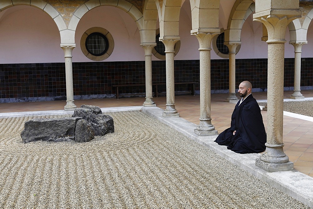 Zen Buddhist monk practising Zazen (meditation) in Orval Trappist Abbey's Zen garden, Belgium, Europe