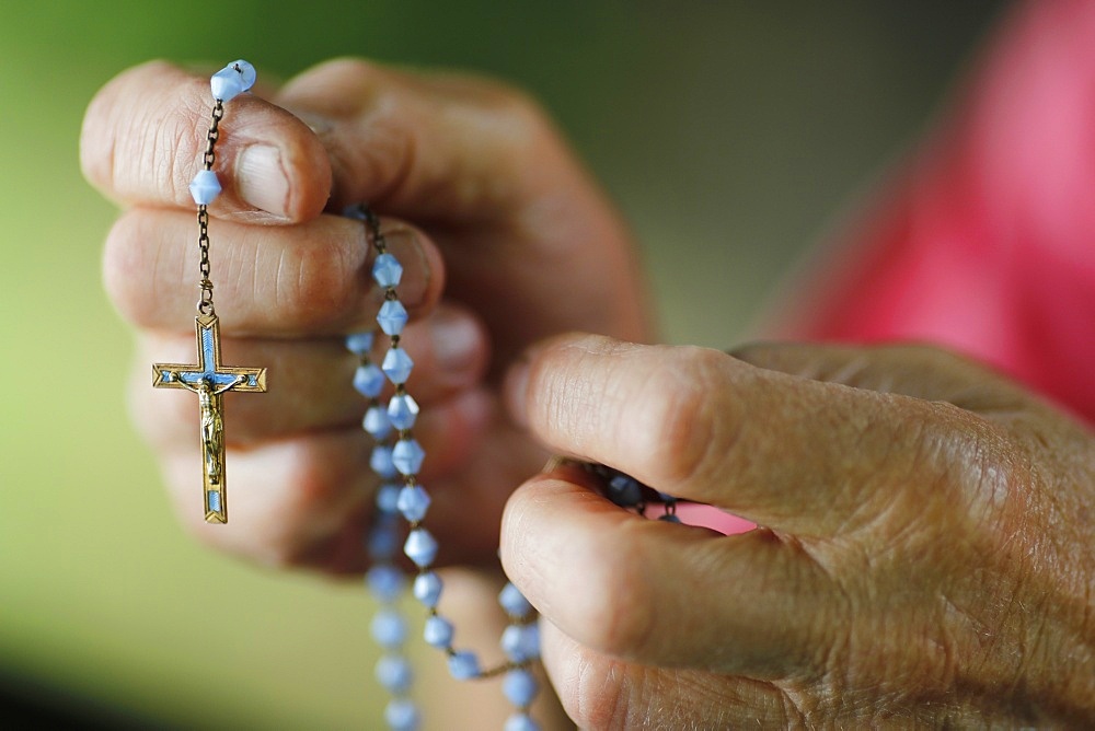 Close-up of a man's hands praying the rosary, France, Europe