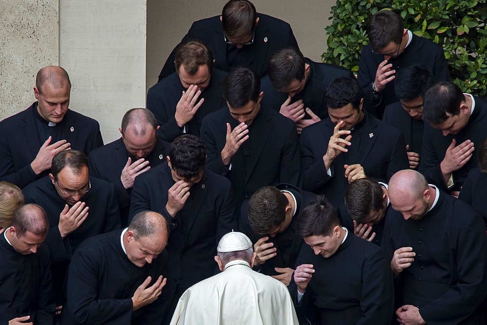 Pope Francis prays with priests at the end of a limited public audience at the San Damaso courtyard in The Vatican, Rome, Lazio, Italy, Europe