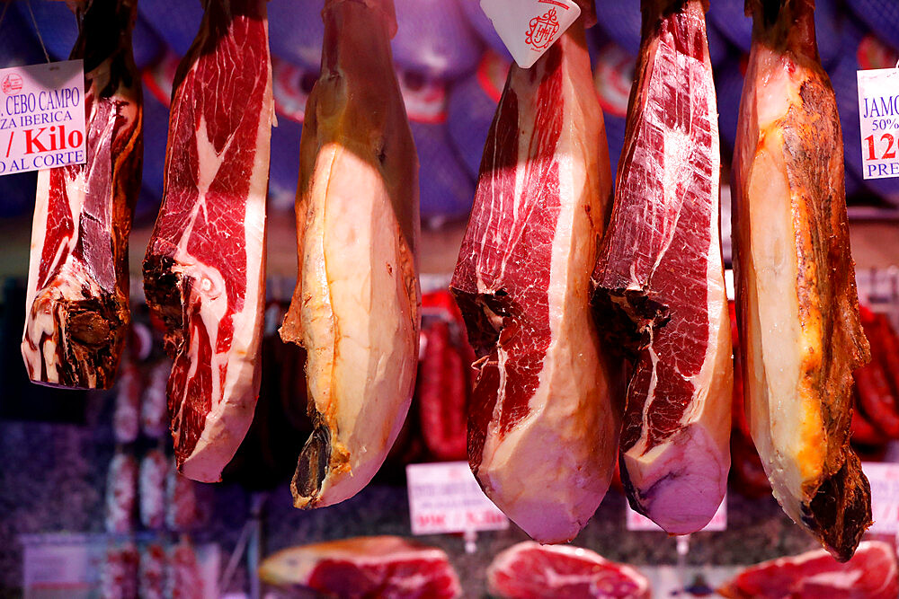 Cured ham (Jamon Iberico) hanging at market, Madrid, Spain, Europe