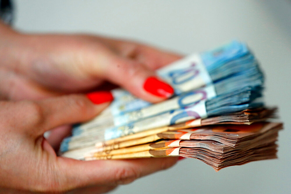 Woman holding euro money banknotes, concept of stealing cash, rich people, savings or spending money, counting payment, France, Europe