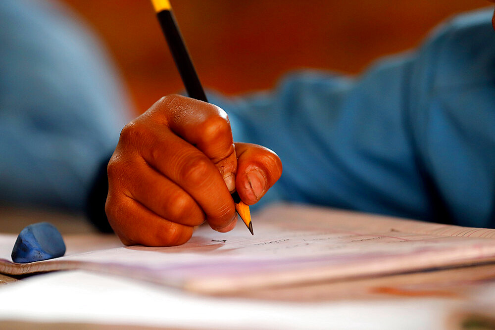 Primary school, boy in classroom, close-up on pencil, concept of education and school life, Kathmandu, Nepal, Asia