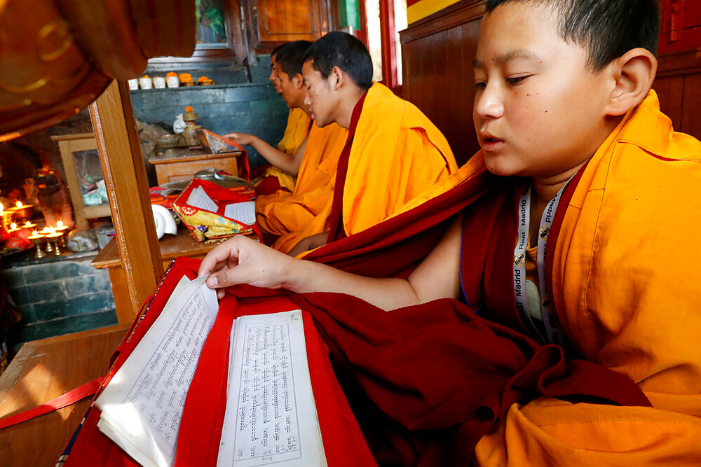 Monks at ceremony with Tibetan Buddhist prayer book in Sanskrit, Ganesh Saraswati Buddhist Temple, Kathmandu, Nepal, Asia