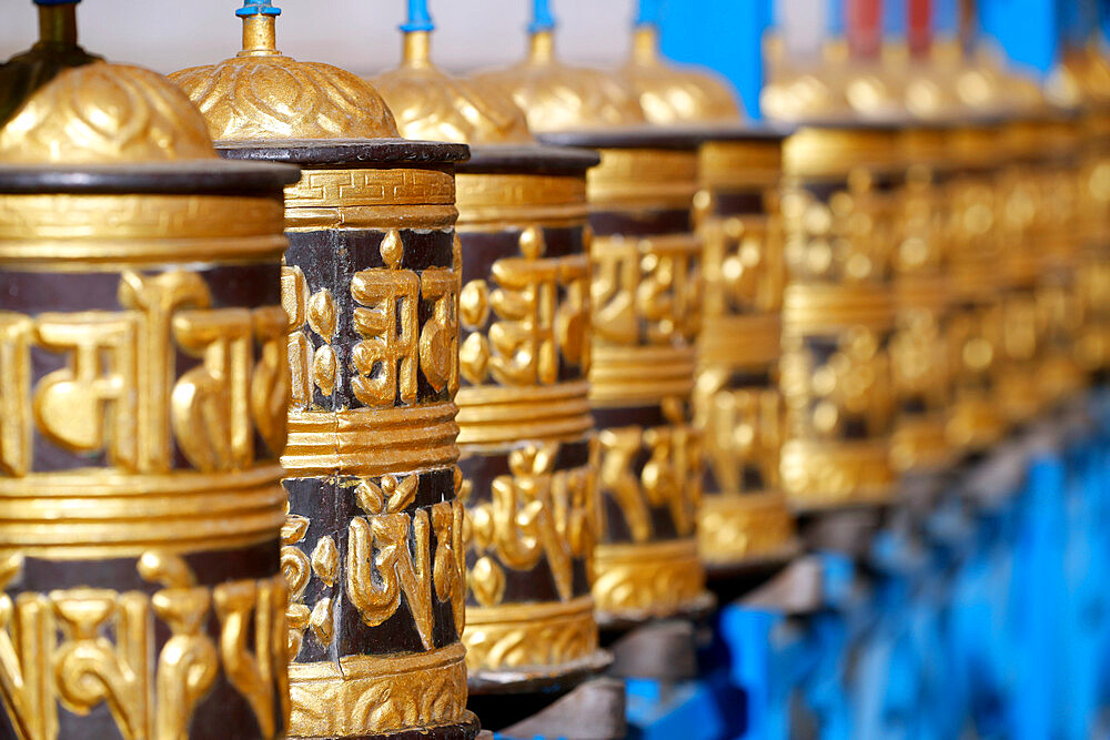 Rolling metal prayer wheels circling, with mantra written in Tibetan language, Shakhya Tharig Buddhist Monastery, Kathmandu, Nepal, Asia