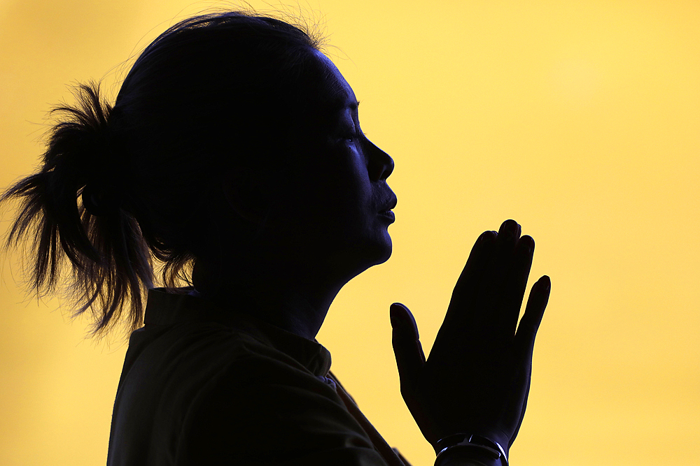 Silhouette of woman praying in temple, Faith and spirituality concept, Vietnam, Indochina, Southeast Asia, Asia