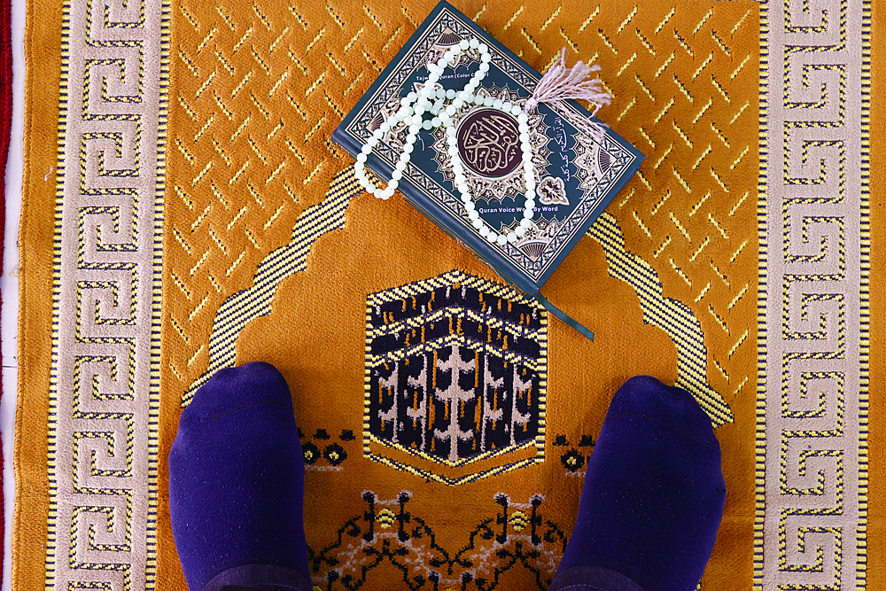 Muslim man praying on Islamic prayer mat with the Kaaba, Symbol of Islam, Chau Doc, Vietnam, Indochina, Southeast Asia, Asia